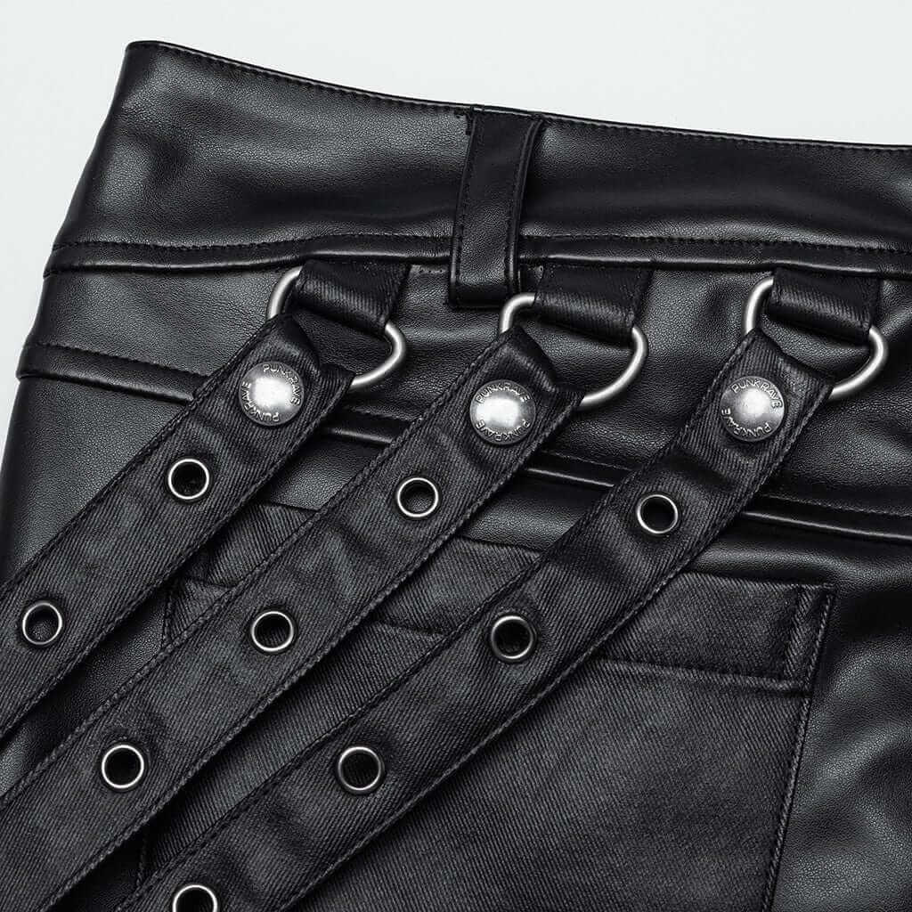 Close-up of Mordanthe Trousers showcasing the unique strap and grommet detailing on stylish black fabric.