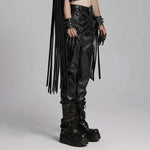 Mordanthe Trousers featuring stylish black faux leather, fringe details, and edgy accessories, perfect for bold fashion statements.